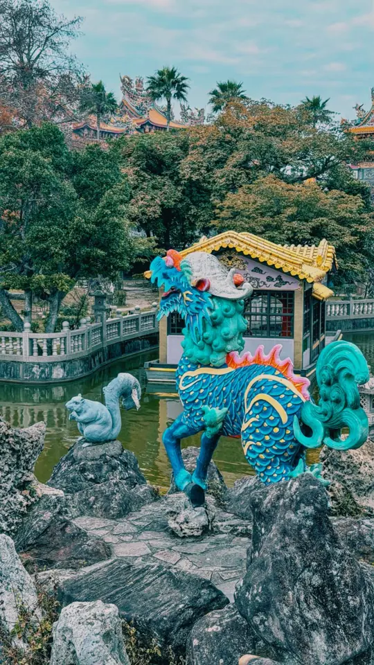 A colourful kirin statue by a pond