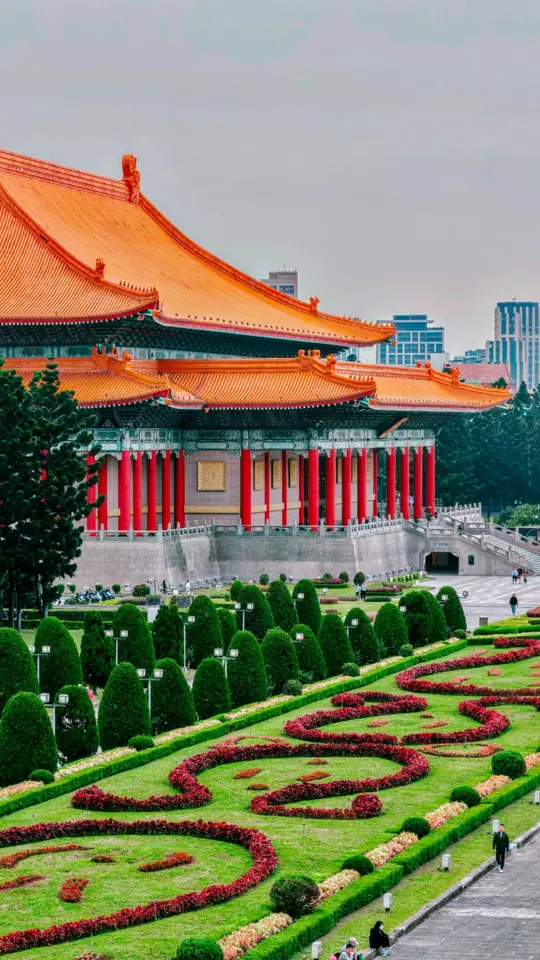 An orange-roofed hall above a patterned garden