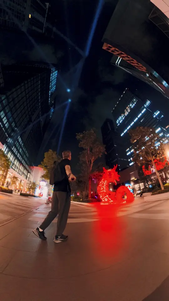 A red neon dragon in a night plaza
